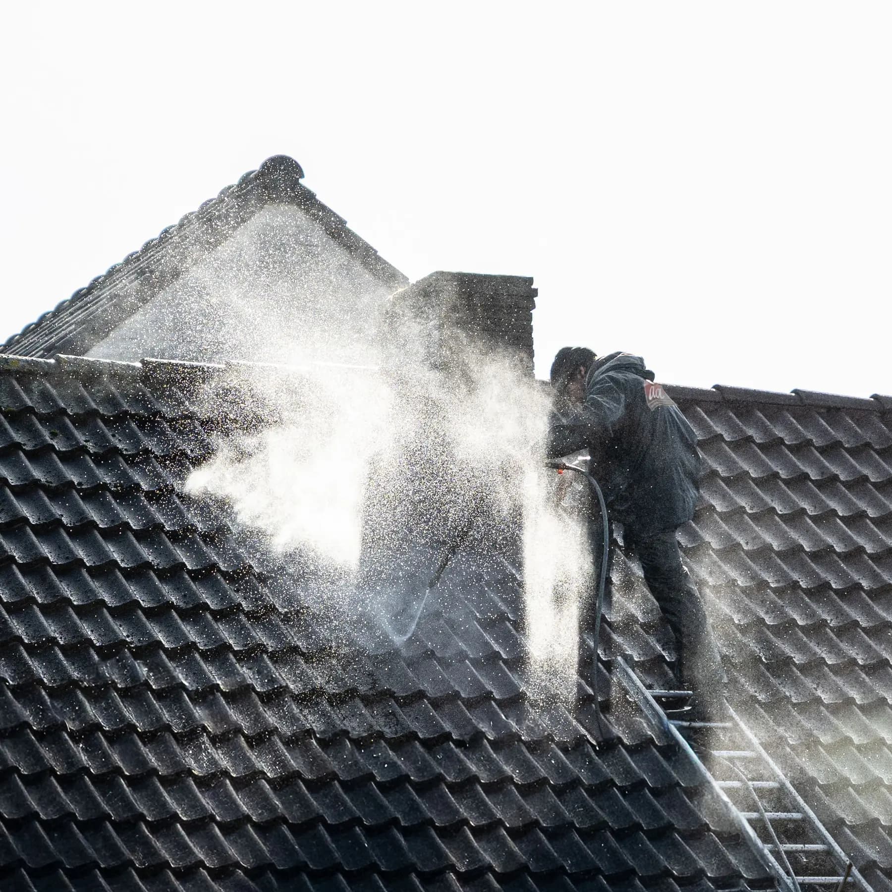 Dak van een woning wordt gereinigd met softwash
